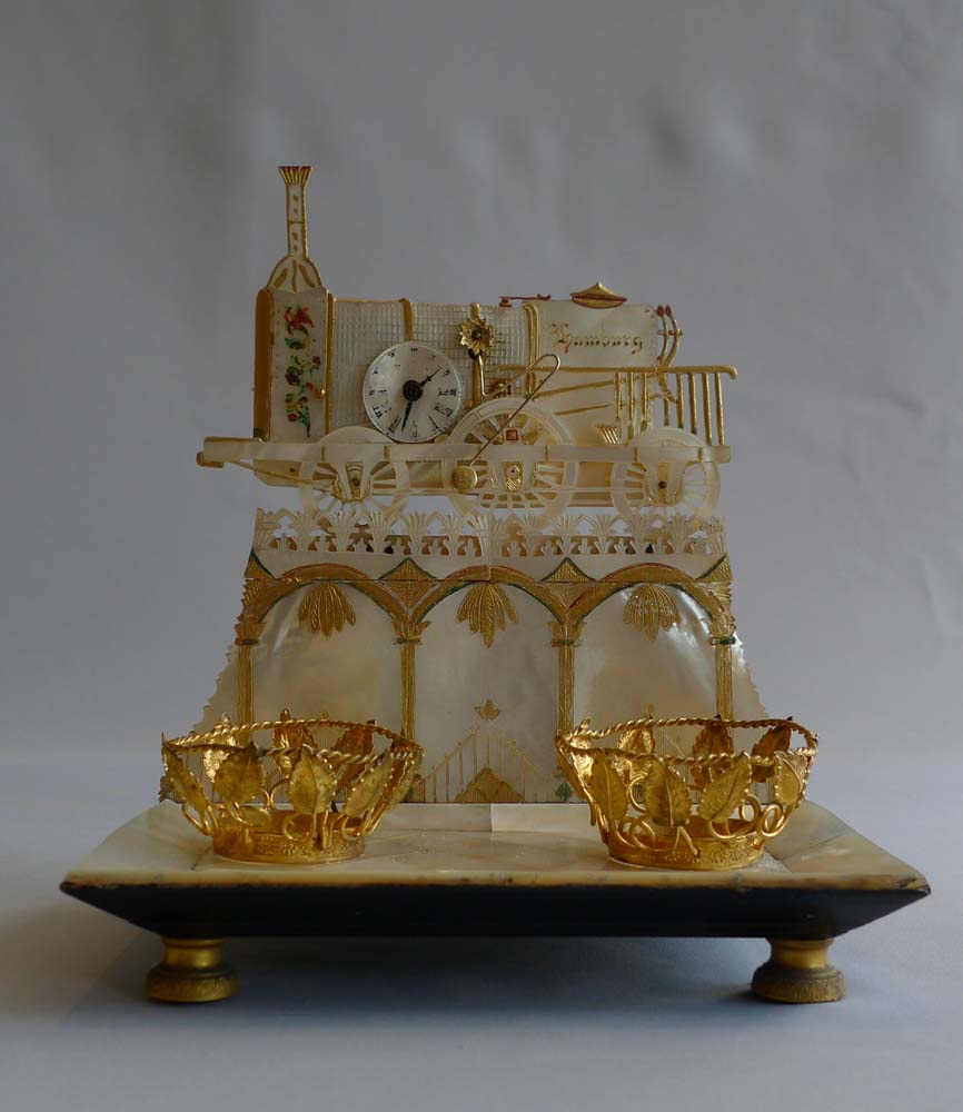 Antique Palais Royal Zapler clock in locomotive form marked Hamburg set on ormolu mounted desk set.