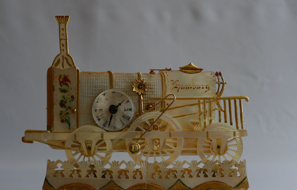 Antique Palais Royal Zapler clock in locomotive form marked Hamburg set on ormolu mounted desk set.