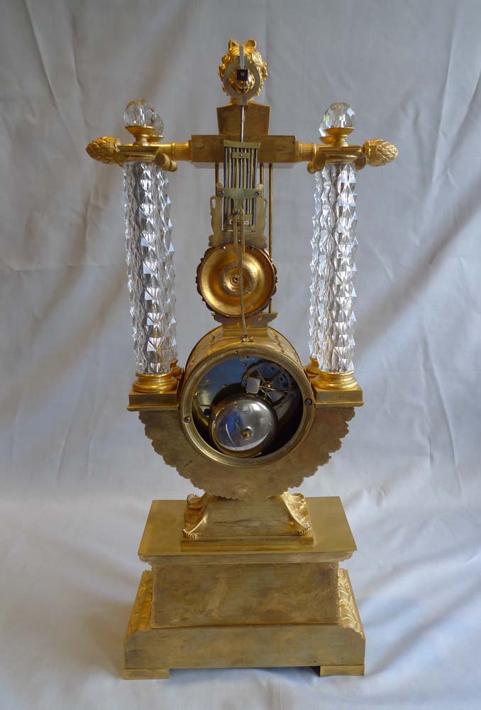 Rare antique mantel clock in crystal and ormolu, Charles X period with remote pendulum.
