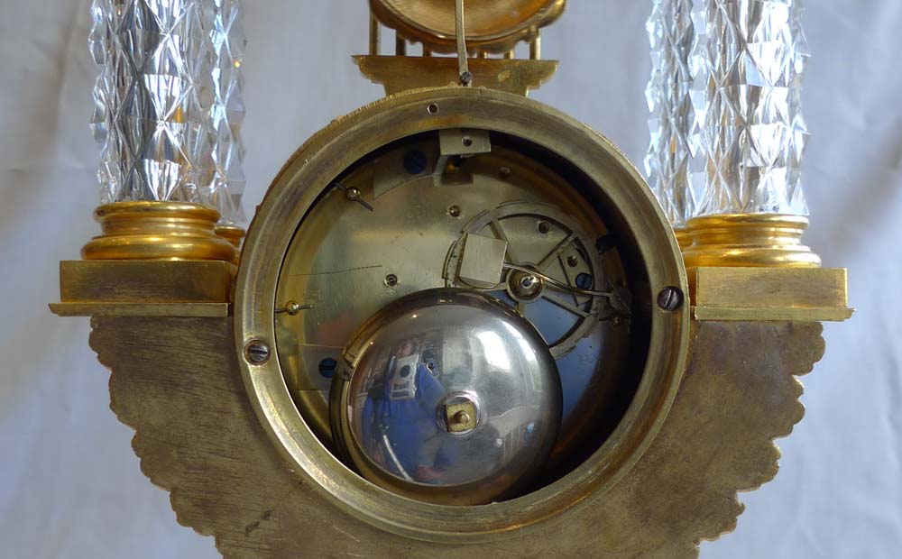Rare antique mantel clock in crystal and ormolu, Charles X period with remote pendulum.