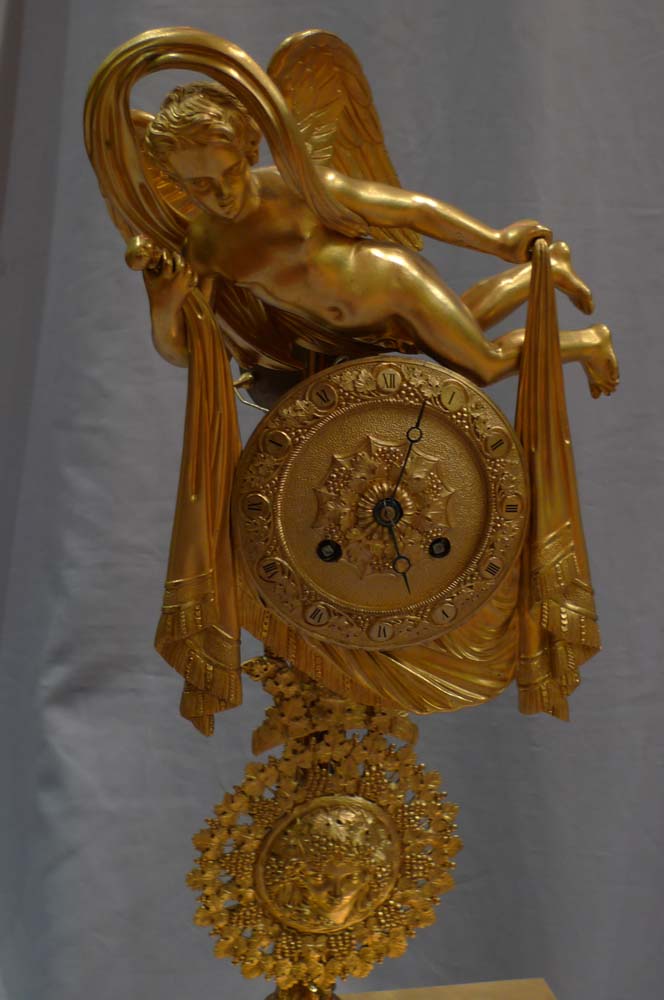 Antique French 19th century mantel clock of Cupid floating over clouds.