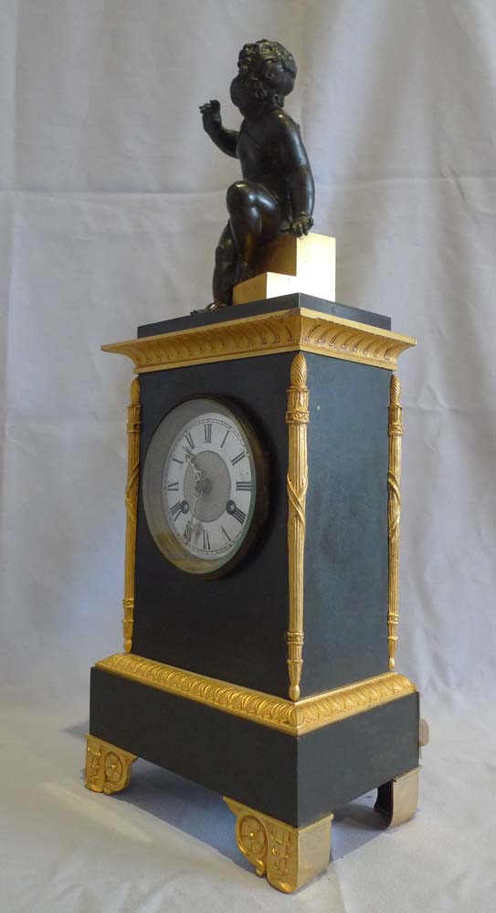 Antique Charles X mantel clock in patinated bronze and ormolu.