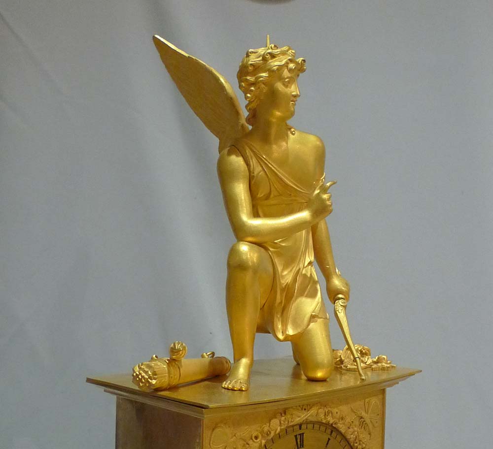 Antique French ormolu mantel clock of Charles X period of a kneeling Cupid.