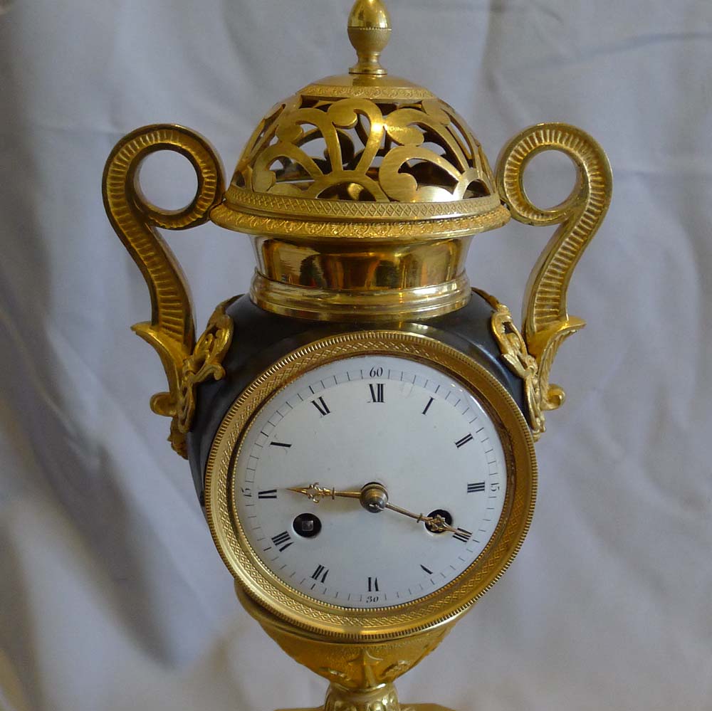 Antique French Empire patinated bronze and ormolu vase clock dated 1810.