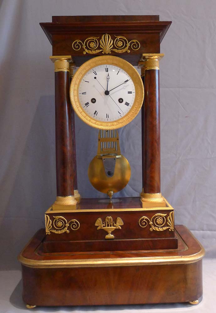 Antique French Empire period, flame mahogany and ormolu mounted musical portico clock.