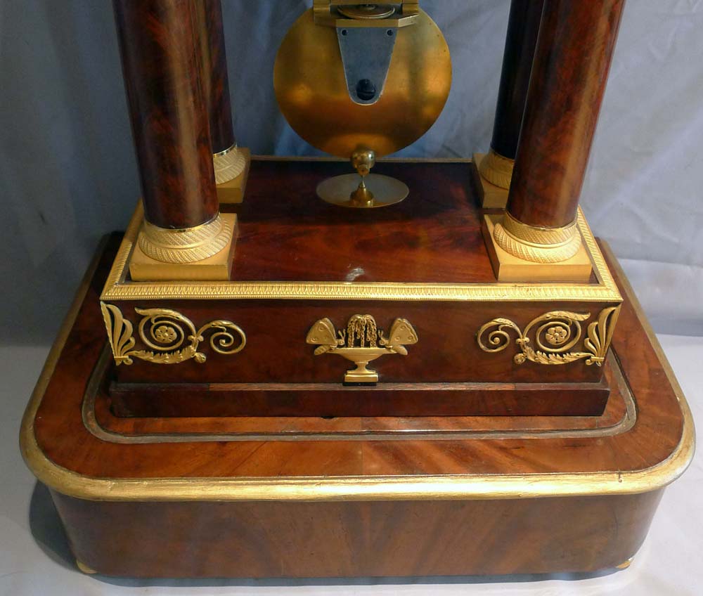 Antique French Empire period, flame mahogany and ormolu mounted musical portico clock.