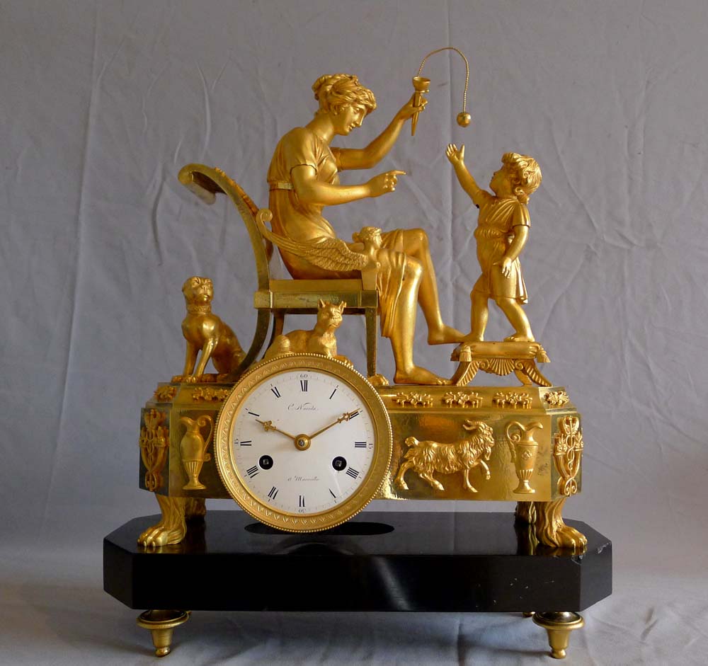 Fine French Empire clock of woman playing with child in ormolu and black marble.