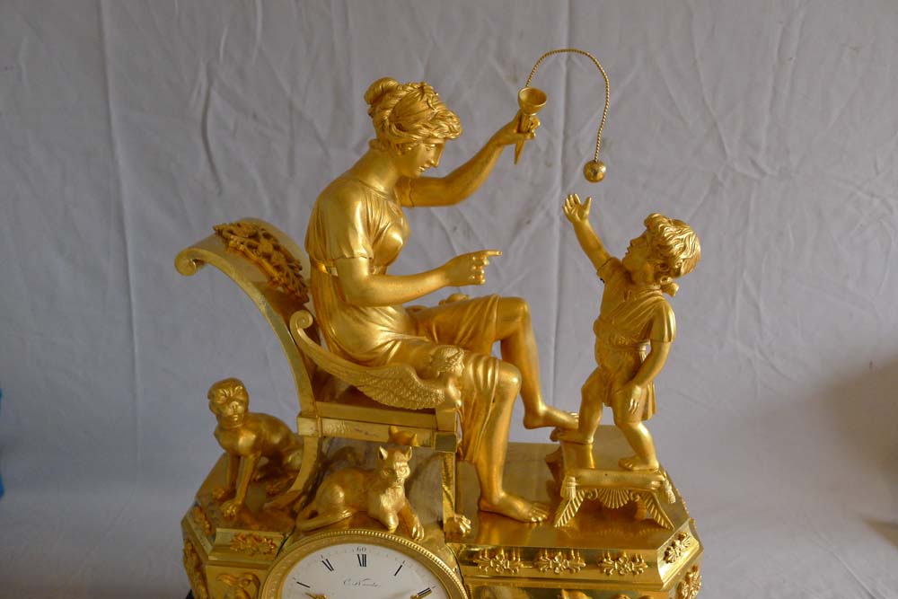 Fine French Empire clock of woman playing with child in ormolu and black marble.