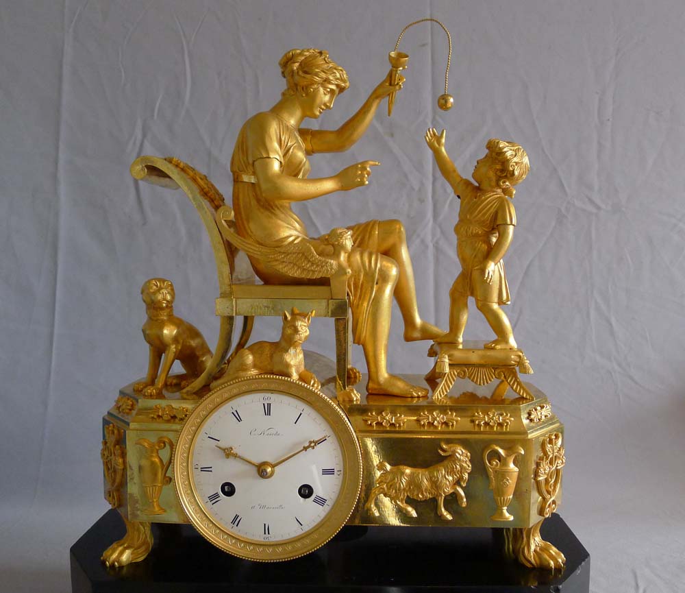 Fine French Empire clock of woman playing with child in ormolu and black marble.