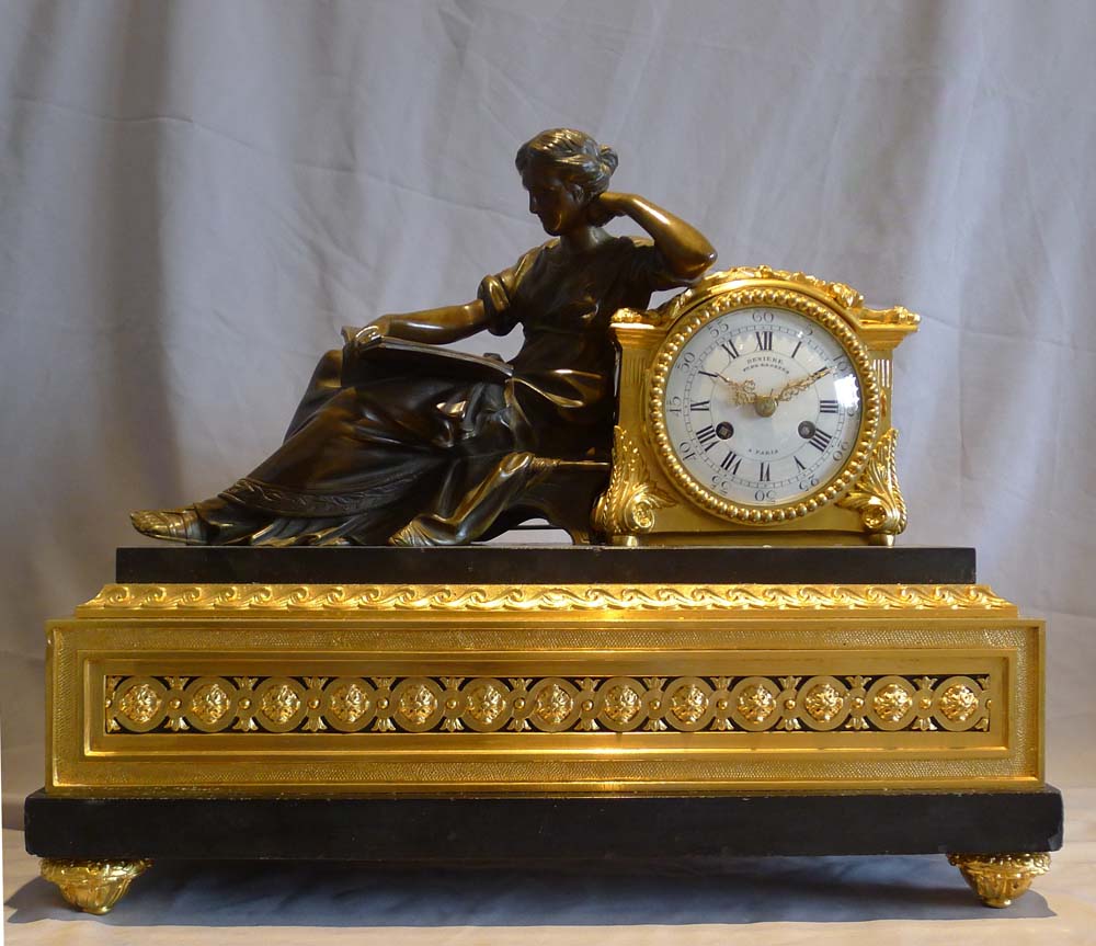 Antique French mantel clock in ormolu, black marble and patinated bronze of woman reading.