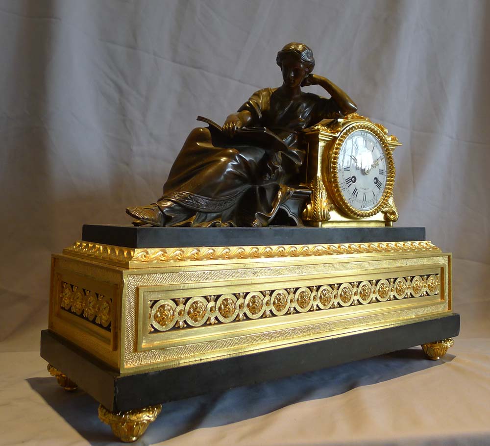 Antique French mantel clock in ormolu, black marble and patinated bronze of woman reading.