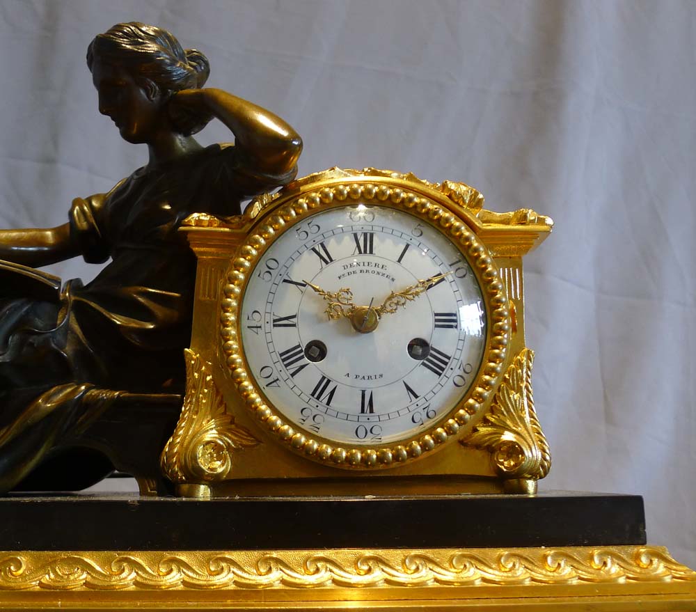 Antique French mantel clock in ormolu, black marble and patinated bronze of woman reading.