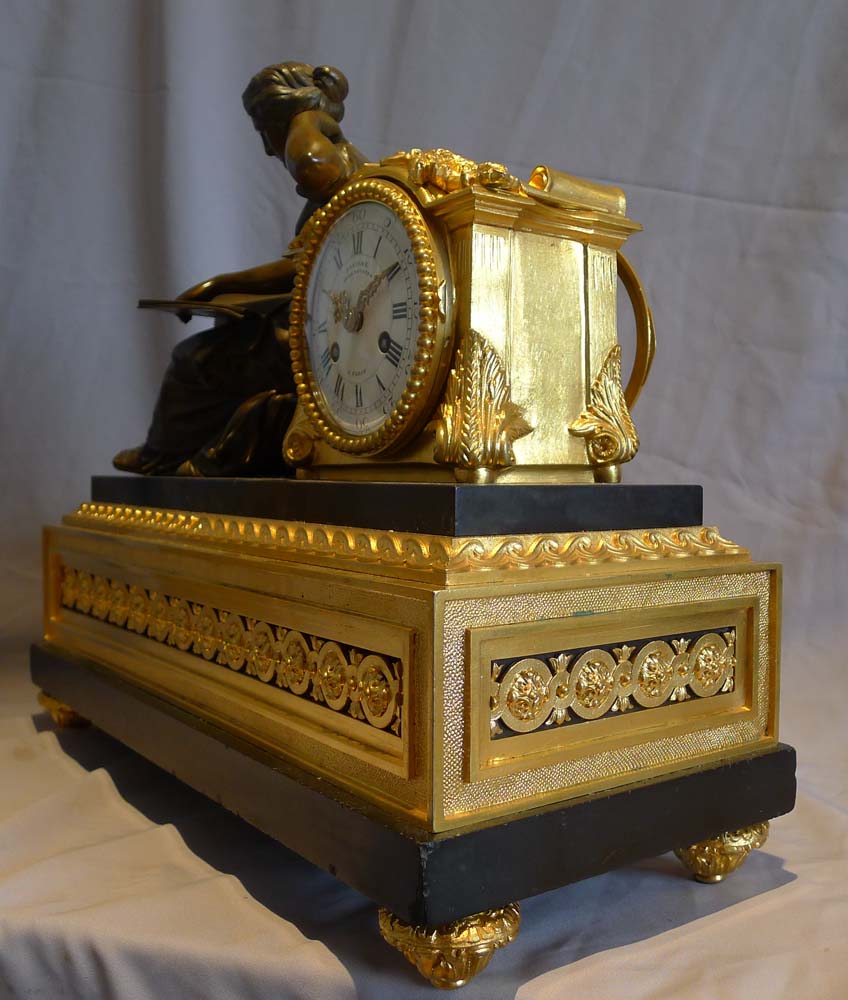 Antique French mantel clock in ormolu, black marble and patinated bronze of woman reading.