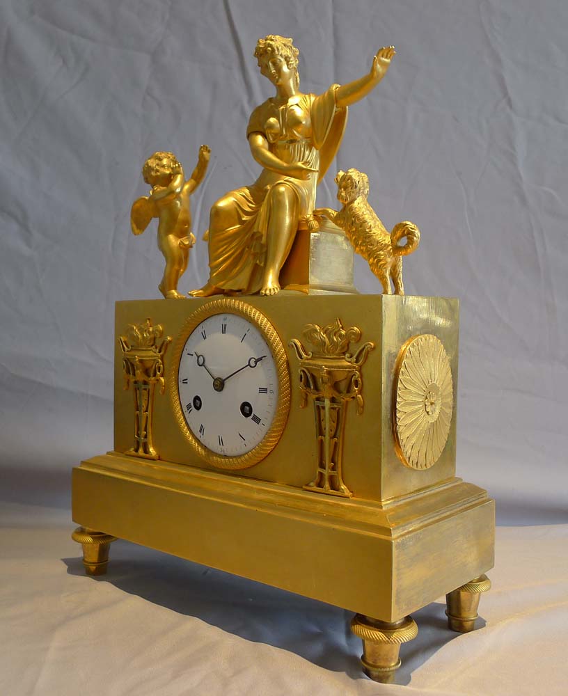 Antique ormolu French Empire mantel clock of woman playing with dog.