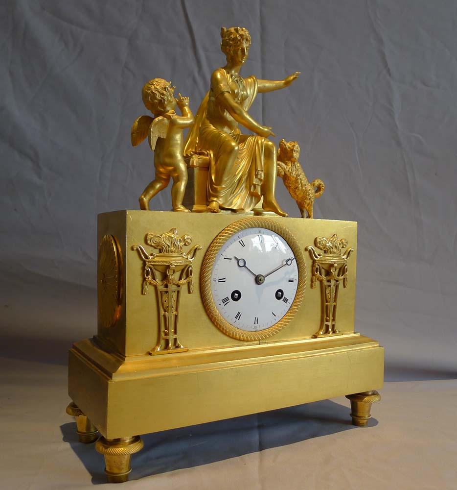 Antique ormolu French Empire mantel clock of woman playing with dog.