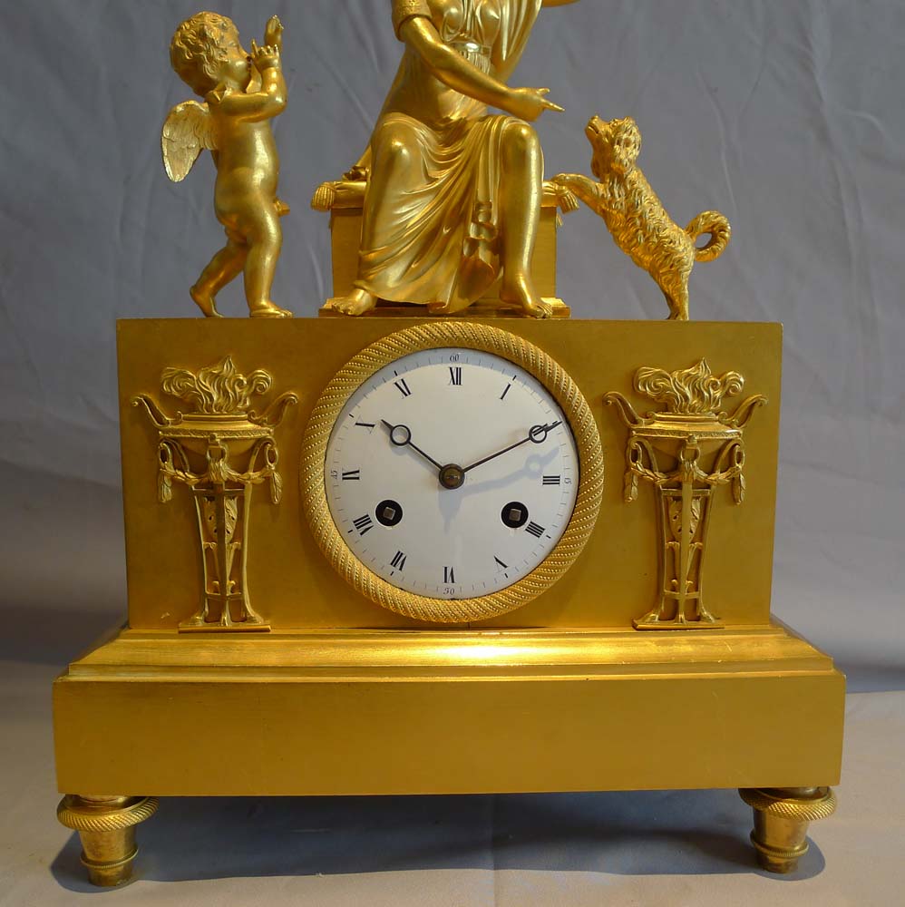 Antique ormolu French Empire mantel clock of woman playing with dog.