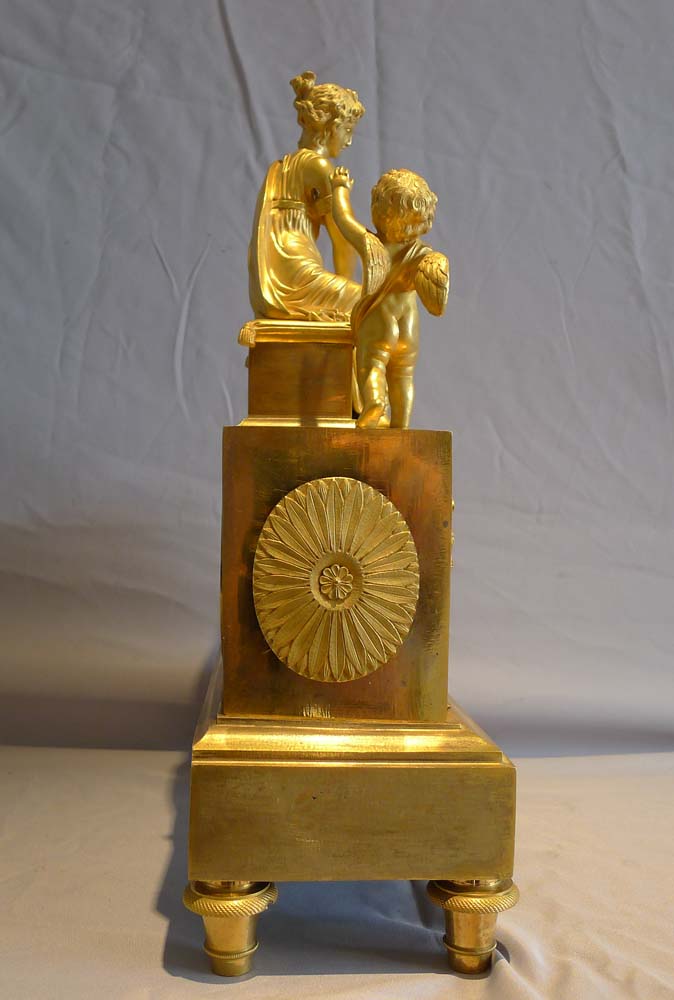 Antique ormolu French Empire mantel clock of woman playing with dog.