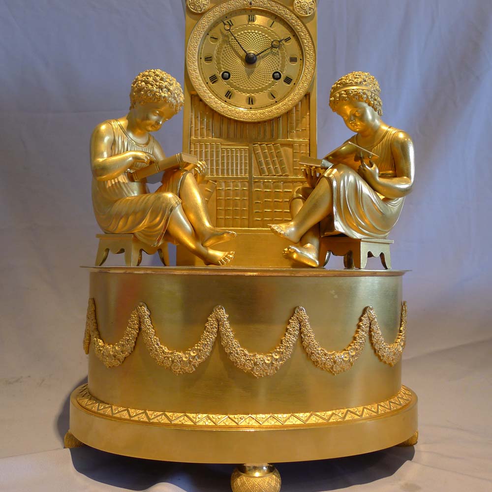 Antique French Empire ormolu library clock of two children reading before a book case