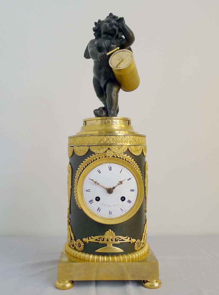 Antique French Ist Empire clock in patinated bronze and ormolu of cupid playing a drum.