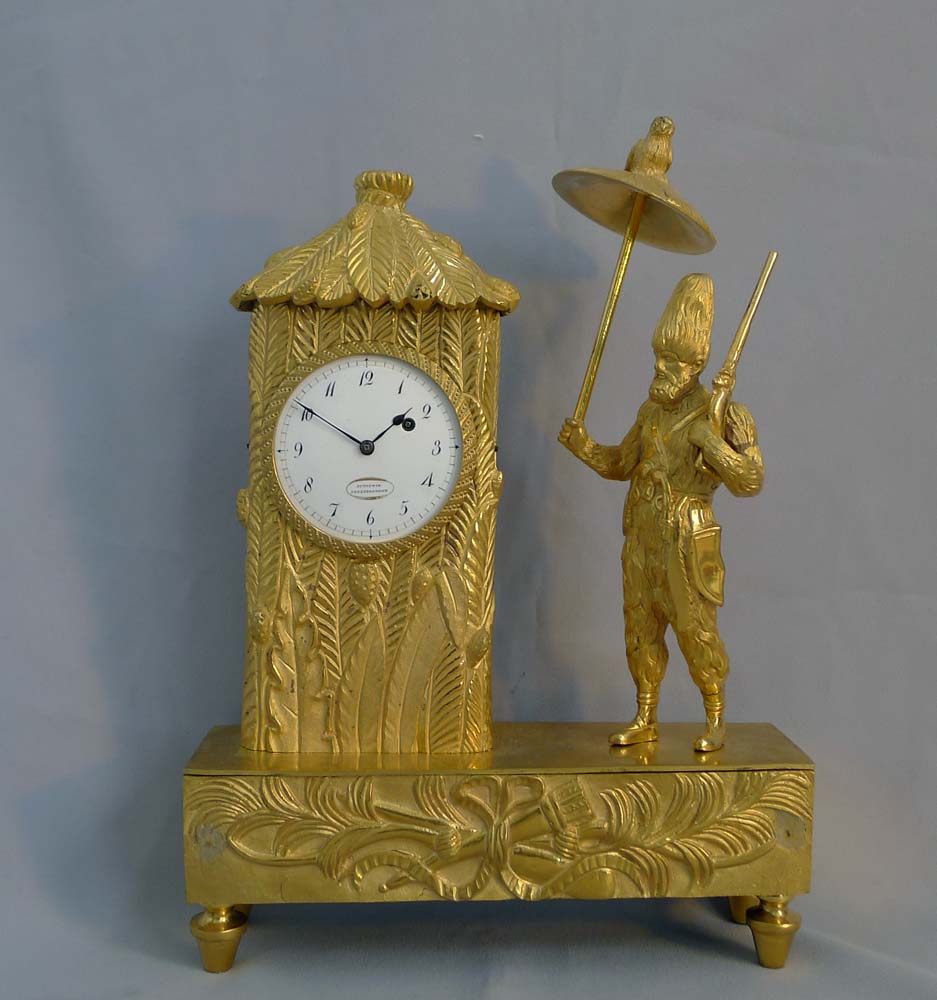 Antique French Empire miniature ormolu mantel clock representing Robinson Crusoe outside his hut.