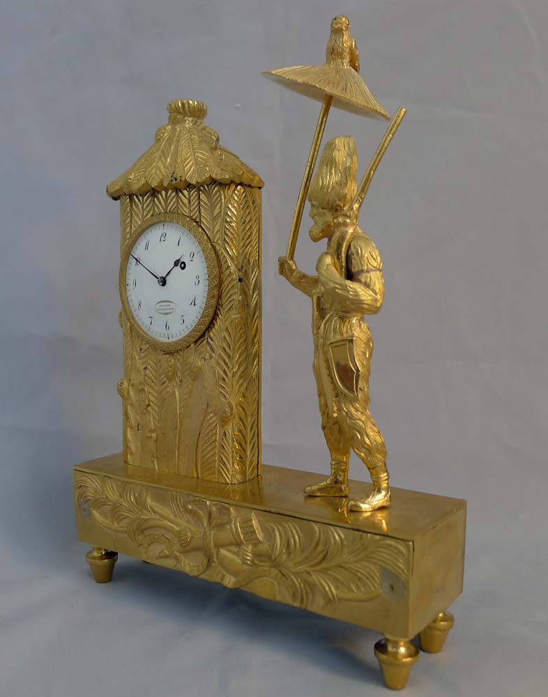 Antique French Empire miniature ormolu mantel clock representing Robinson Crusoe outside his hut.
