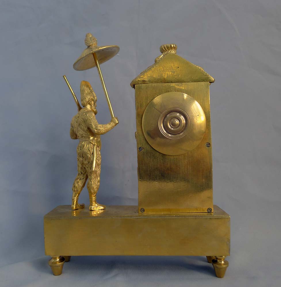 Antique French Empire miniature ormolu mantel clock representing Robinson Crusoe outside his hut.
