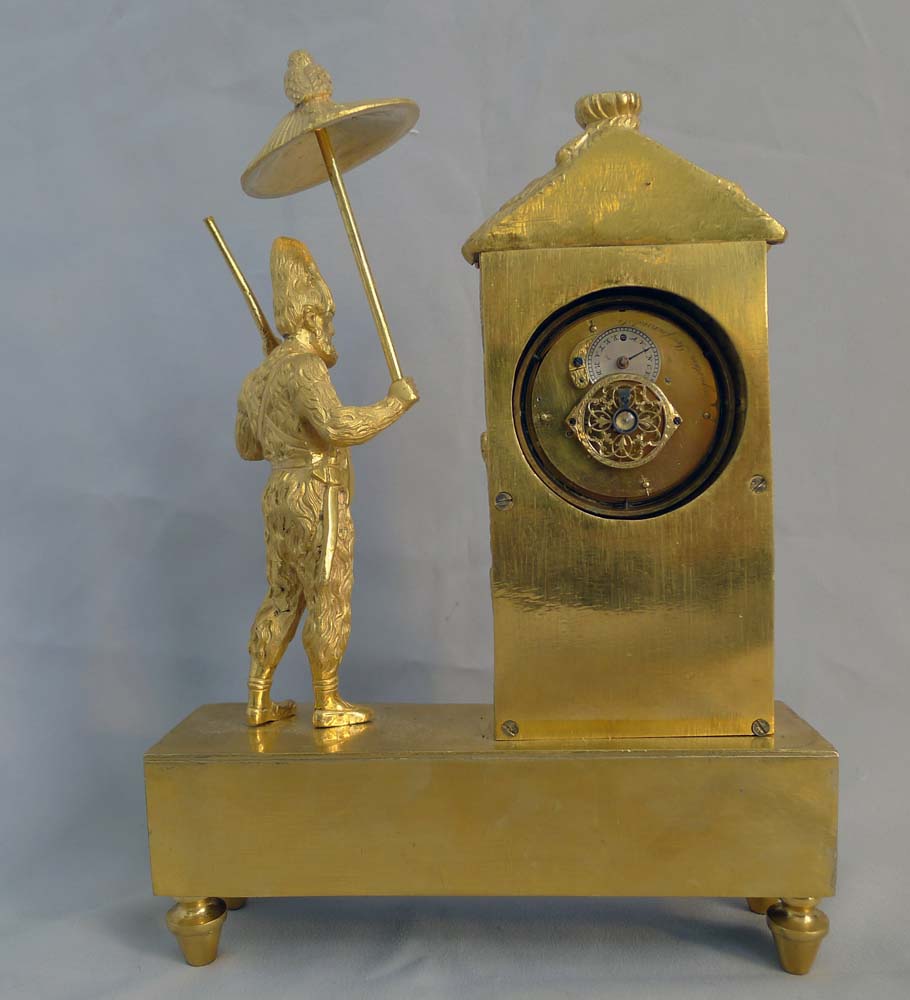 Antique French Empire miniature ormolu mantel clock representing Robinson Crusoe outside his hut.