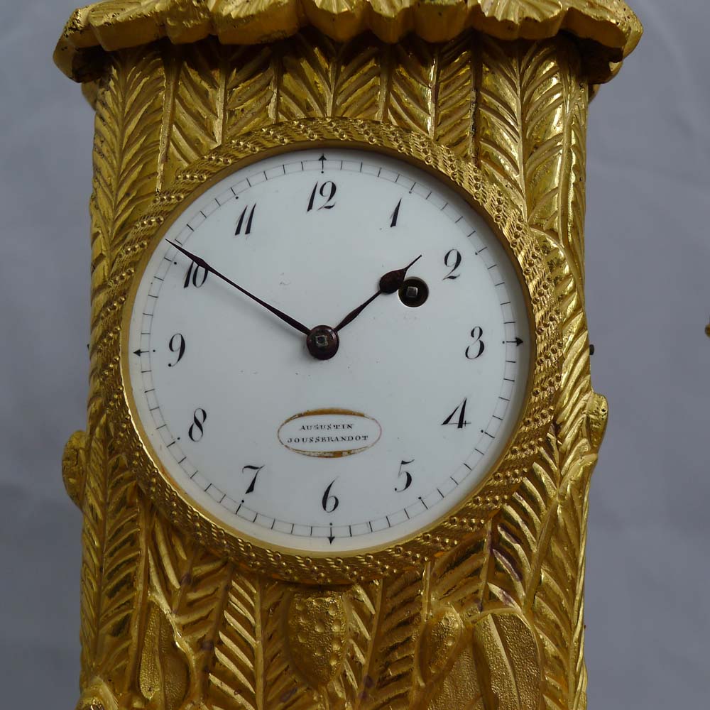 Antique French Empire miniature ormolu mantel clock representing Robinson Crusoe outside his hut.