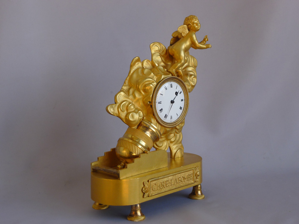 Antique French Empire ormolu miniature clock of Cupid being fired from a motar.