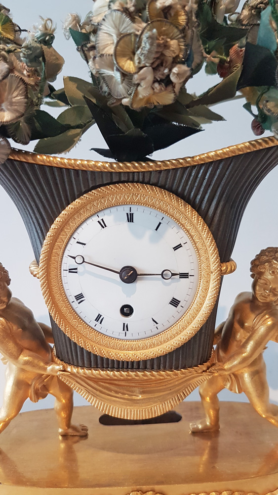 French Empire Ormolu and Patinated Bronze Clock of Amorettis holding up Basket Flowers