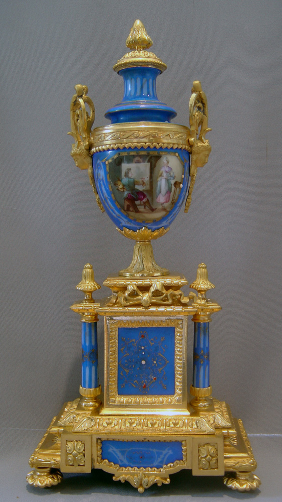 French antique clock set in porcelain and ormolu with silver highlights.