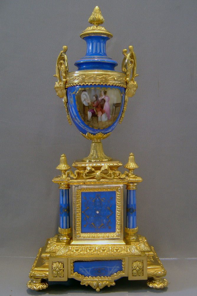 French antique clock set in porcelain and ormolu with silver highlights.