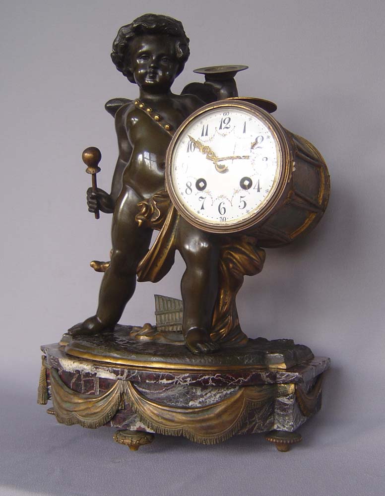 Antique clock French patinated and gilt bronze with griotte marble of Cupid playing drum and cymbal.