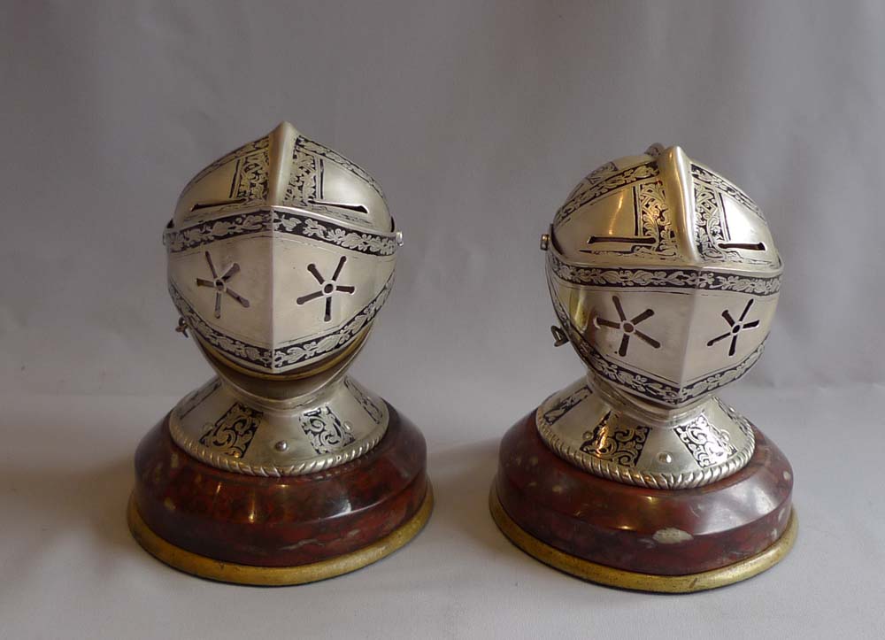 Antique desk clock and barometer in form of silvered and engraved medieval helmets with visors.