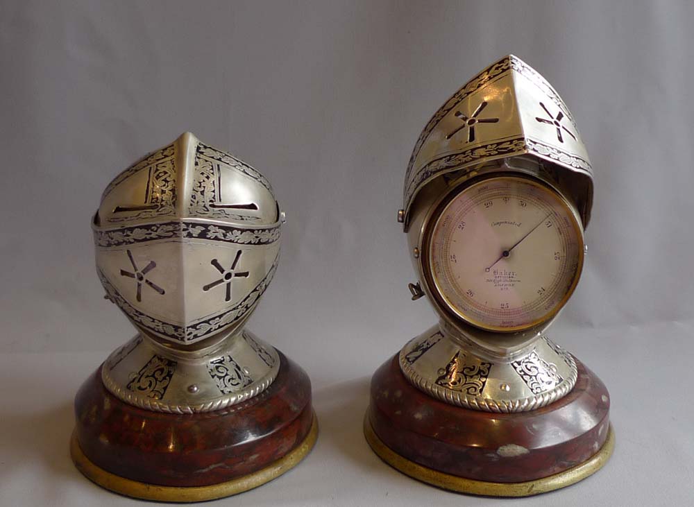 Antique desk clock and barometer in form of silvered and engraved medieval helmets with visors.