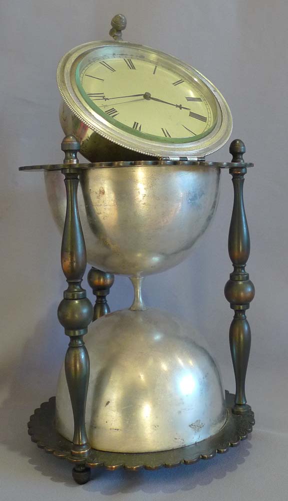 Antique and rare desk clock in the form of an hour glass in patinated and silvered bronze.