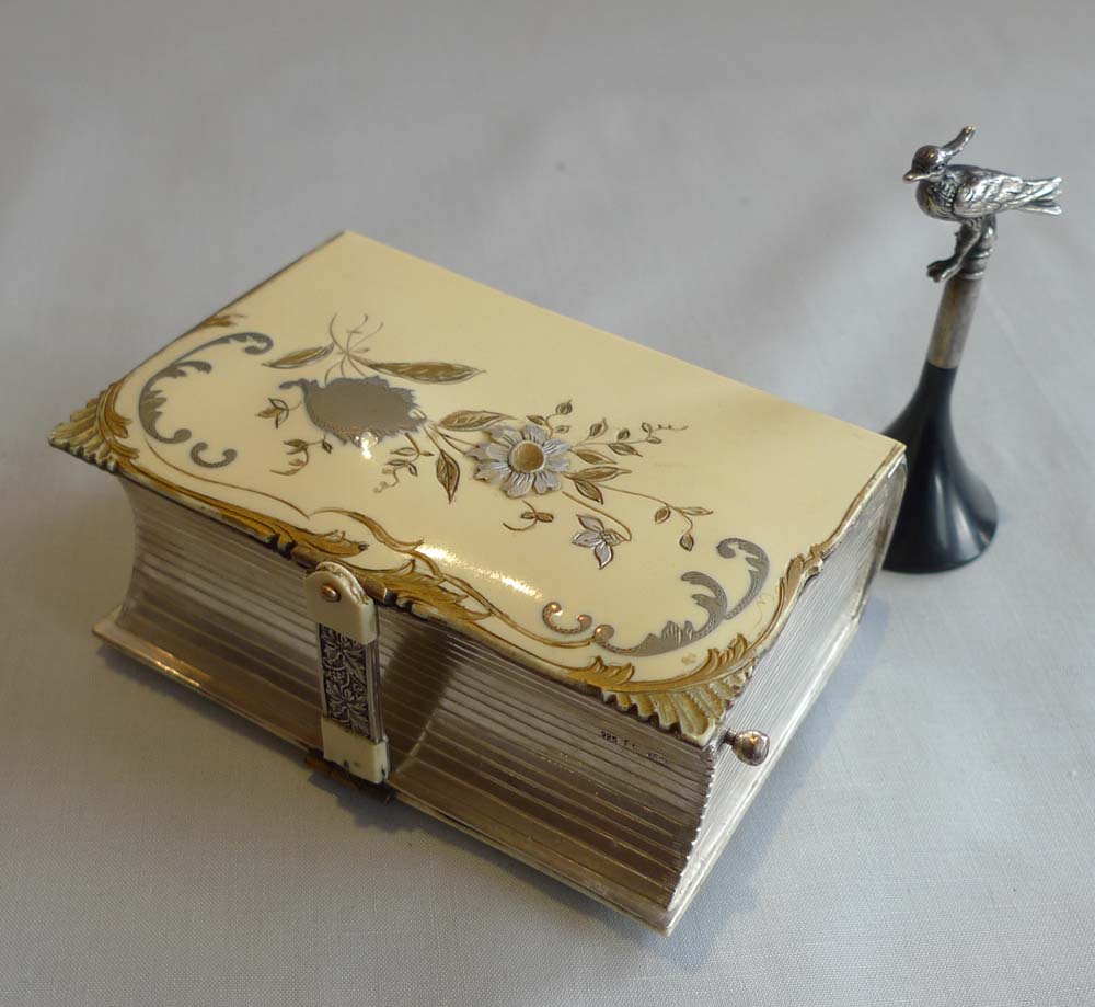 Singing bird box in silver and enamelling in book form by Griesbaum.