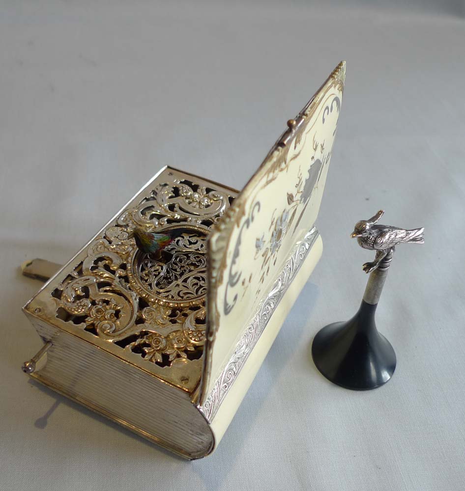 Singing bird box in silver and enamelling in book form by Griesbaum.