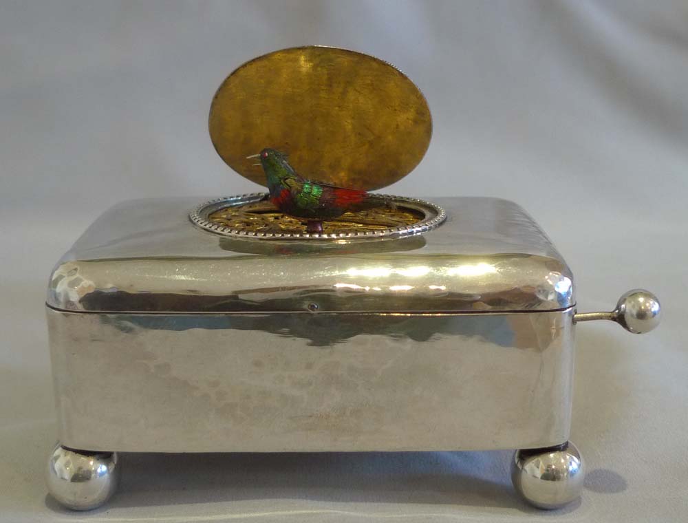 Antique singing bird box in hammered silver case.