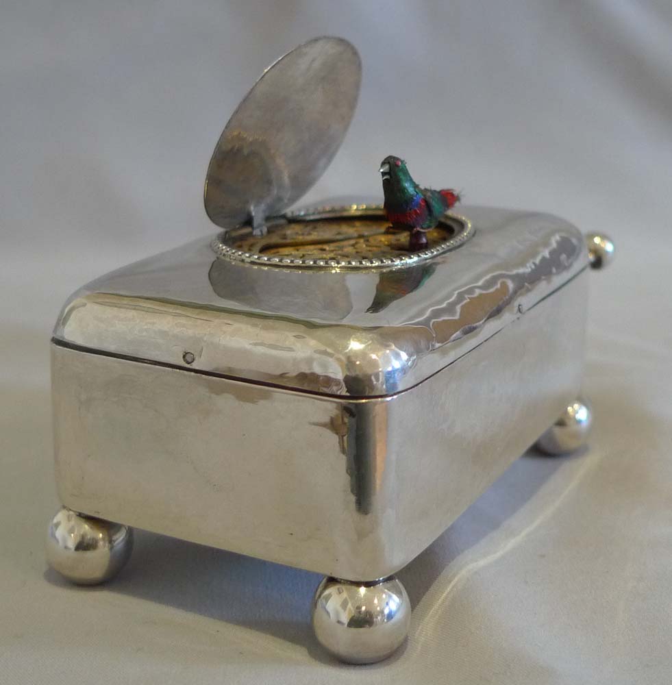 Antique singing bird box in hammered silver case.