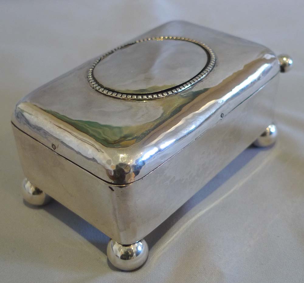 Antique singing bird box in hammered silver case.