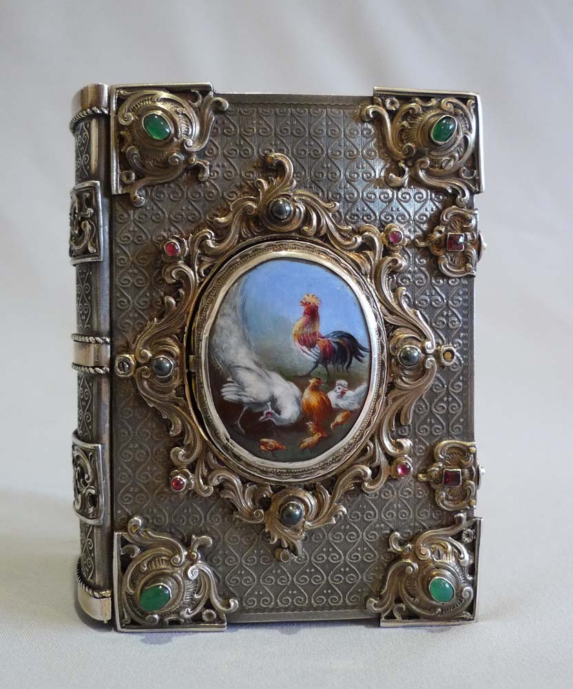 Singing bird box in form of a jewelled book in silver with enamel hand painting.