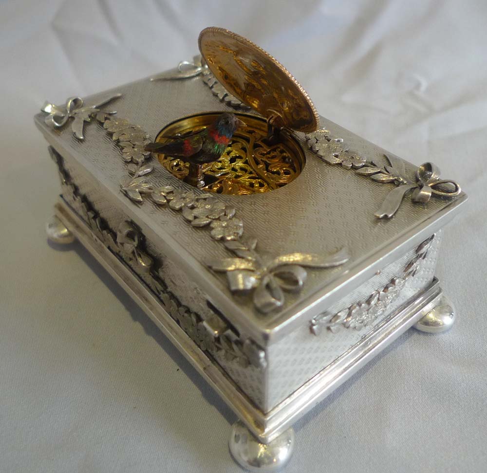 Singing bird box in solid silver with applied swags and bows..