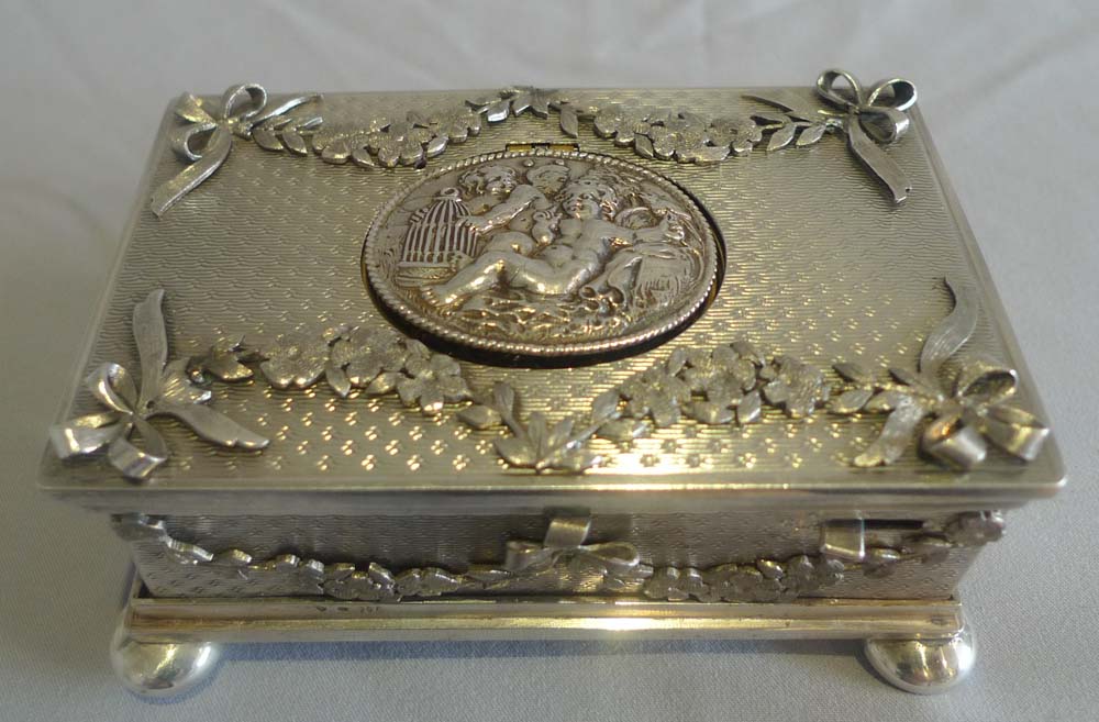 Singing bird box in solid silver with applied swags and bows..