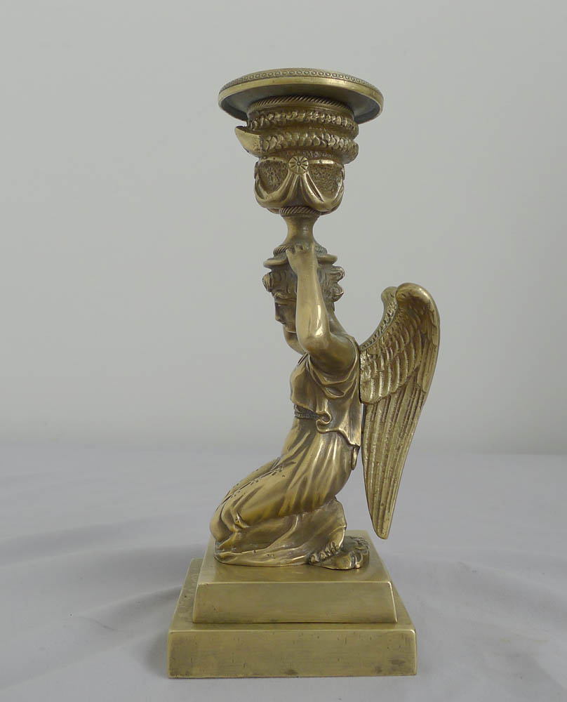 Antique pair of English bronze candlesticks of kneeling winged figures.