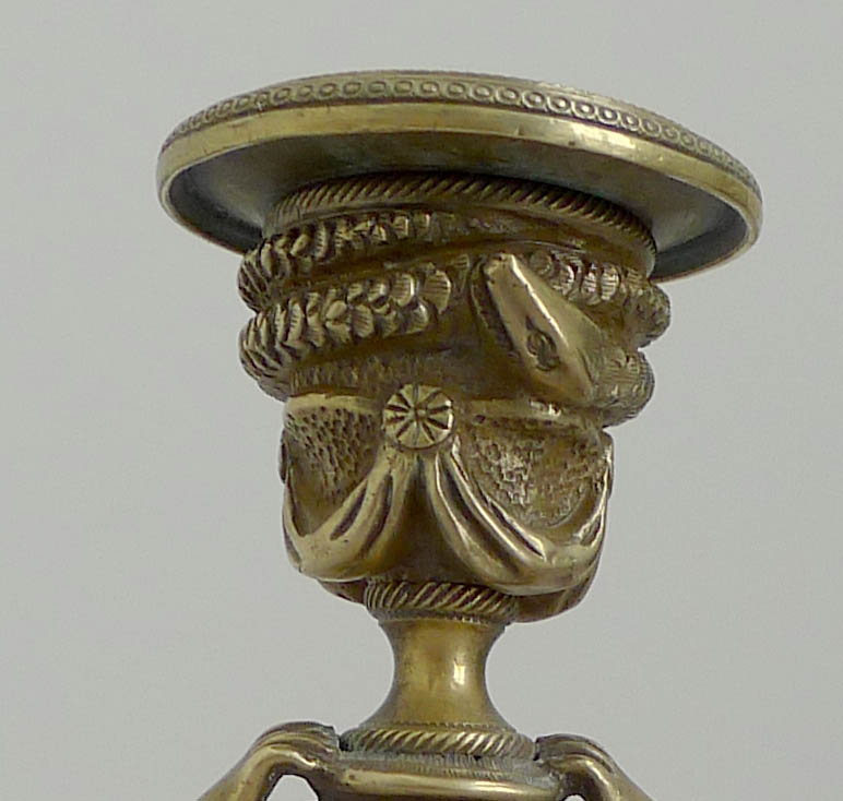 Antique pair of English bronze candlesticks of kneeling winged figures.